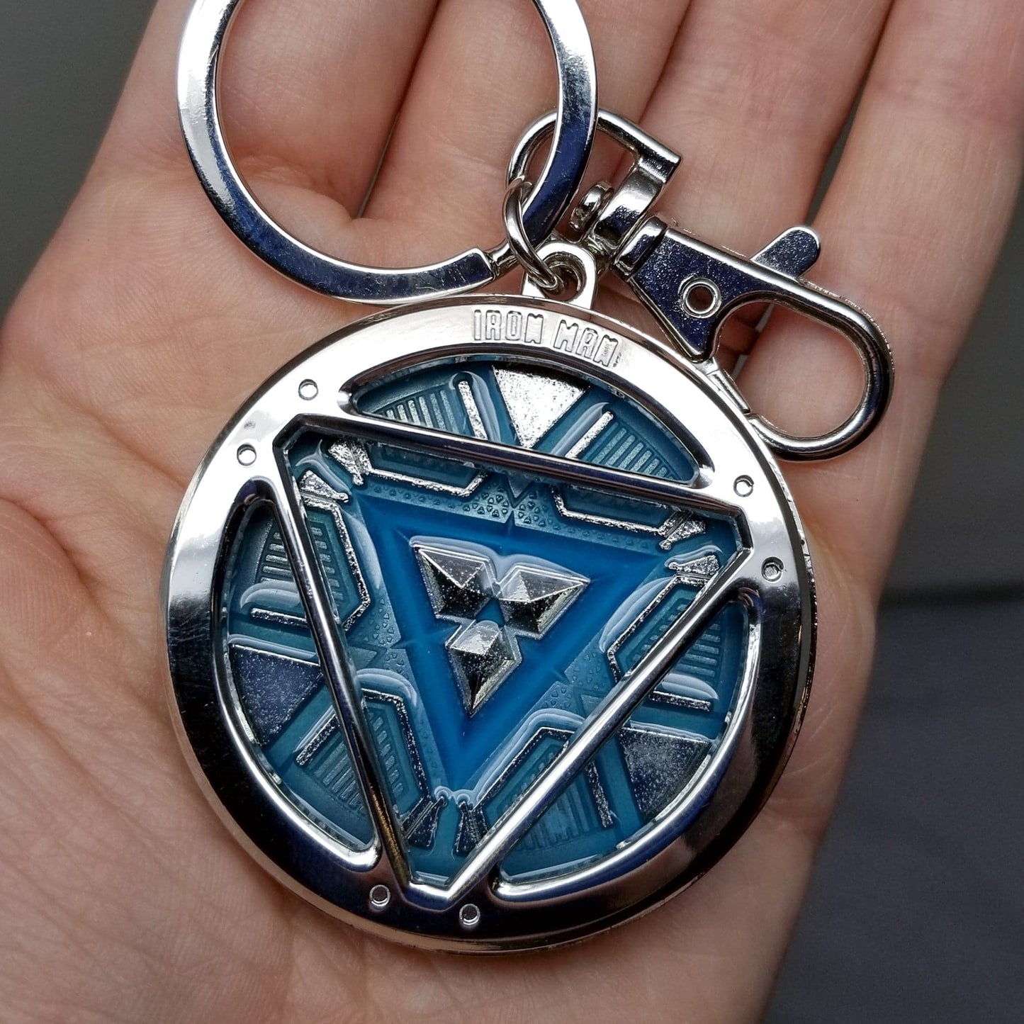 Iron Man Glow-In-The-Dark Pewter Arc Reactor Keychain. In Celebration of Tony Stark’s Iron Man as seen in the Marvel Studios Avengers films, this oversize pewter Arc Reactor glow-in-the-dark metal keychain features the Arc Reactor powering Tony’s chest and power suit in Iron Man 3. 2 inches across & nearly 1/2 inch thick! Features “Iron Man” logo on the back Includes stainless steel keyring and clip Blue Glow-in-the-Dark effect! Carry your own Proof that Tony Stark Has a Heart