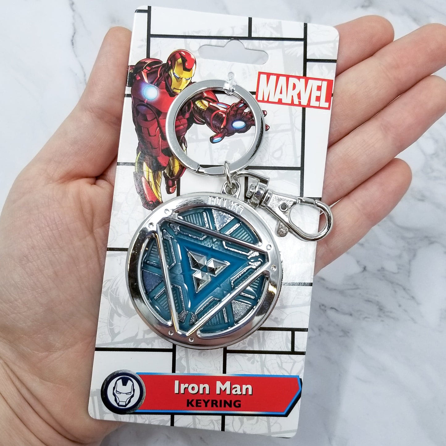 Iron Man Glow-In-The-Dark Pewter Arc Reactor Keychain. In Celebration of Tony Stark’s Iron Man as seen in the Marvel Studios Avengers films, this oversize pewter Arc Reactor glow-in-the-dark metal keychain features the Arc Reactor powering Tony’s chest and power suit in Iron Man 3. 2 inches across & nearly 1/2 inch thick! Features “Iron Man” logo on the back Includes stainless steel keyring and clip Blue Glow-in-the-Dark effect! Carry your own Proof that Tony Stark Has a Heart