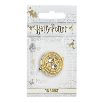 Fixed Time Turner Pin Badge  Worn by Hermione Granger, the Time Turner played a huge part in the Prisoner of Azkaban.  Please be aware that this fixed-pin design does not rotate. This Harry Potter Pin Badge has been created using the official style guide from Warner Bros.  Pin Details:  Around .75" tall and .5" wide (20mm x 16mm) Beautiful gold tone fixed-pin Time Turner with faux crystal bead detail Pin arrives on a printed Harry Potter card backer Quality metal badge pin with butterfly clutch backing  